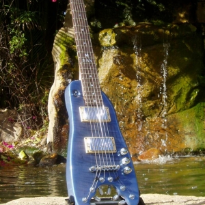 Pearly Blue Rambler Custom Travel Guitar by the waterfall