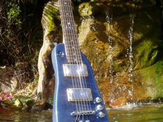 Pearly Blue Rambler Custom Travel Guitar by the waterfall