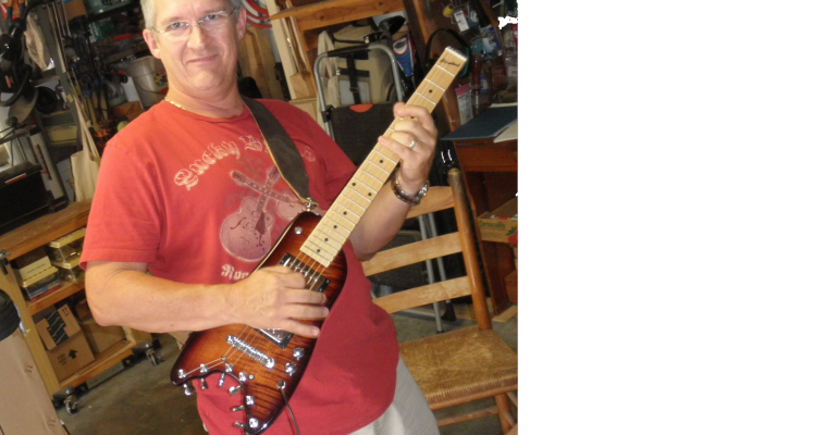 Scott picking up Maple Neck Rambler Travel Guitar